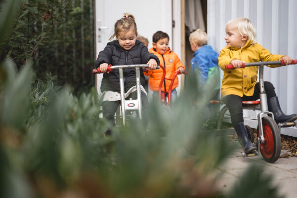 Kinderen buitenspelend op de fiets